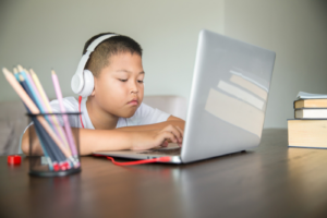 Young student distance learning virtual distance online class on video call virtual lesson, technology studying at home using laptop computer. Parent or tutor teaching child boy with remote education.